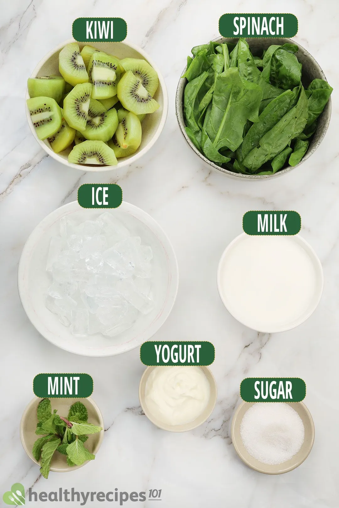 Ingredients for kiwi smoothie, including sliced green kiwi, spinach, mint leaves, and other smoothie essentials.