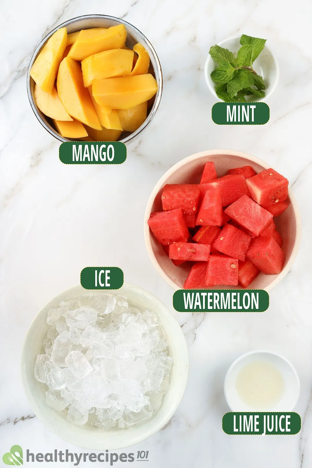 Ingredients for Mango Watermelon Smoothie, including bowls of watermelon triangles, mango wedges, mint leaves, ice, and lime juice.