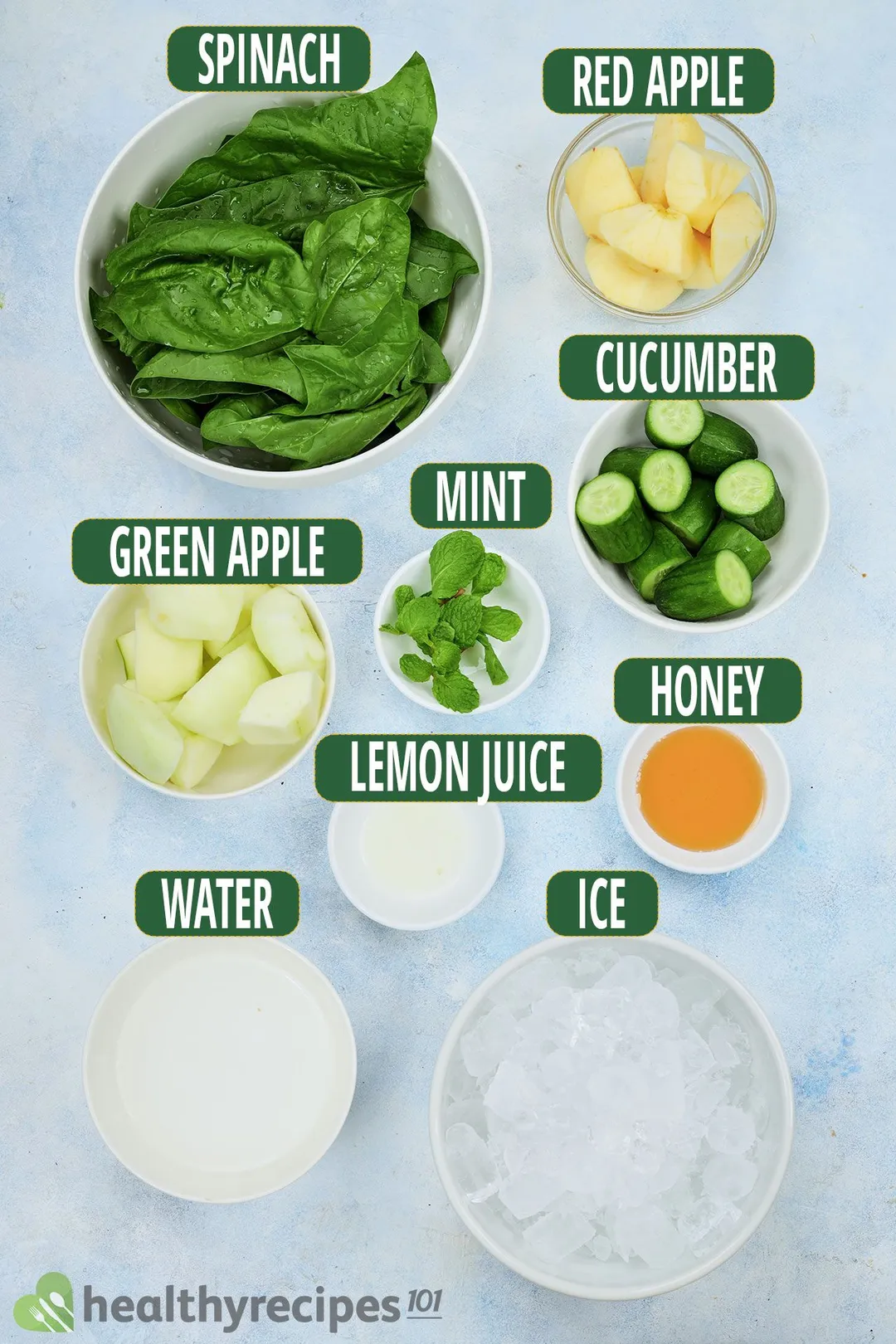 Ingredients for sour apple smoothie, including spinach, apple wedges, green apple wedges, sliced cucumbers, mint leaves, and other smoothie essentials.
