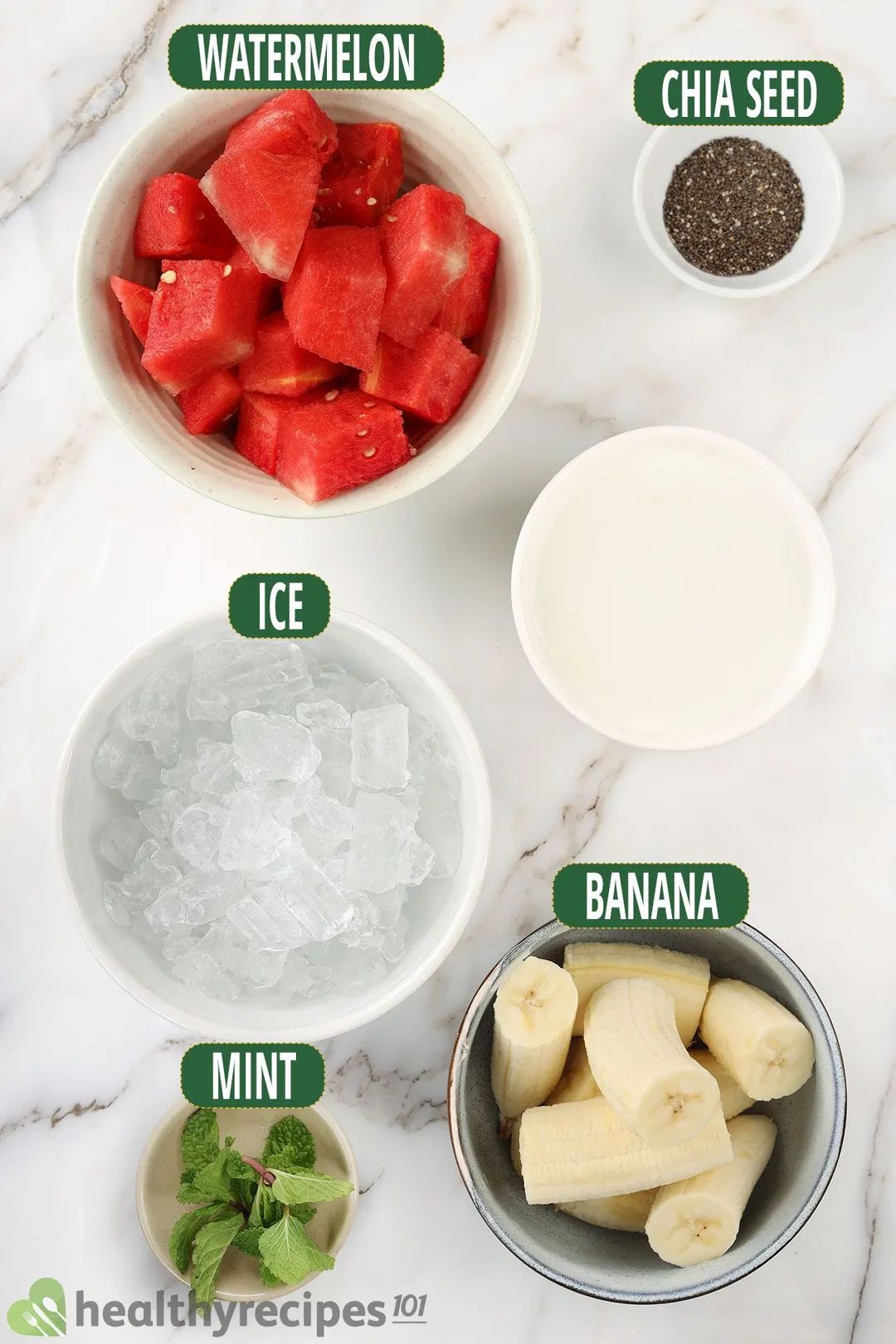 Ingredients for Watermelon Banana Smoothie, including bowls of watermelon slices, chia seeds, ice, peeled bananas, mint leaves, and milk.