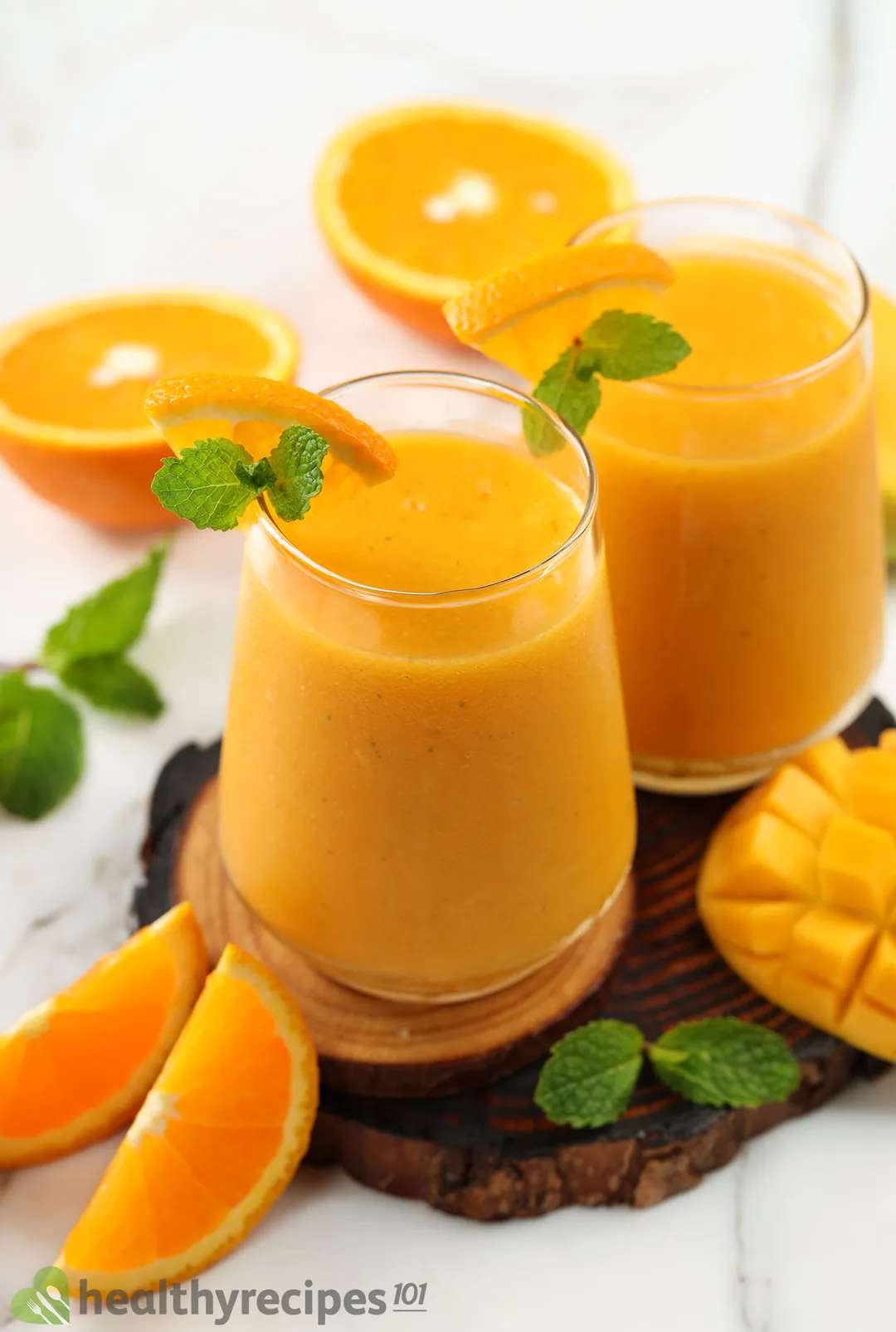 two glasses of mango orange smoothie on a tray