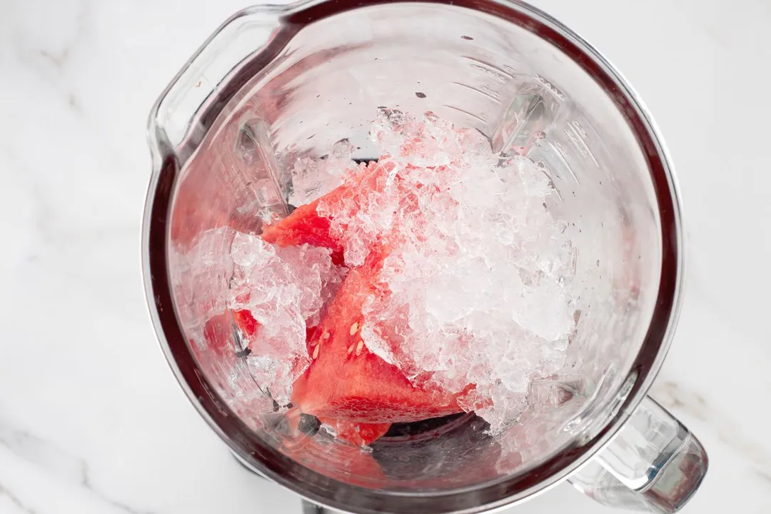 top view of watermelon and ice in a blender pitcher