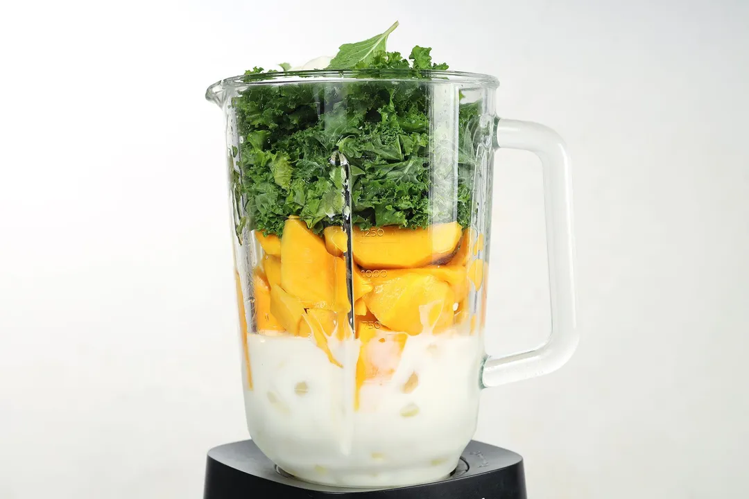 kale, mango cubed and milk in a blender pitcher