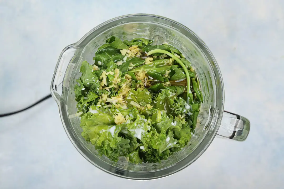 all ingredients for this avocado green smoothie in a blender, about to be blended