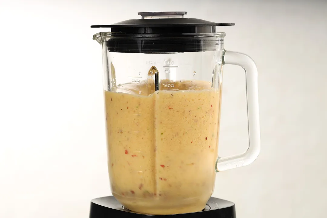 front shot of a blender pitcher of apple orange smoothie