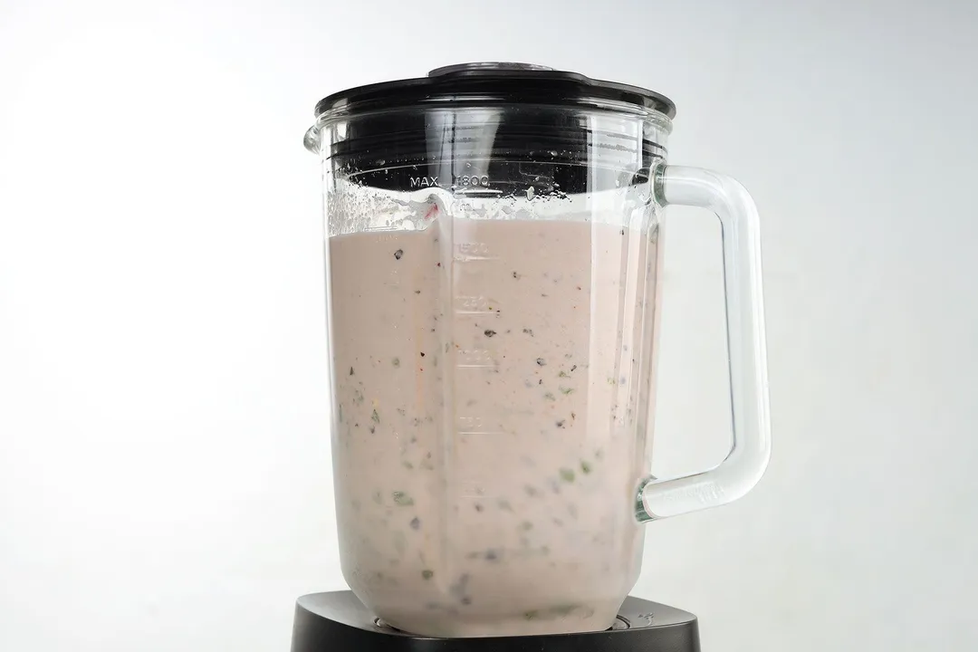 blending blueberry kale smoothie in a blender pitcher