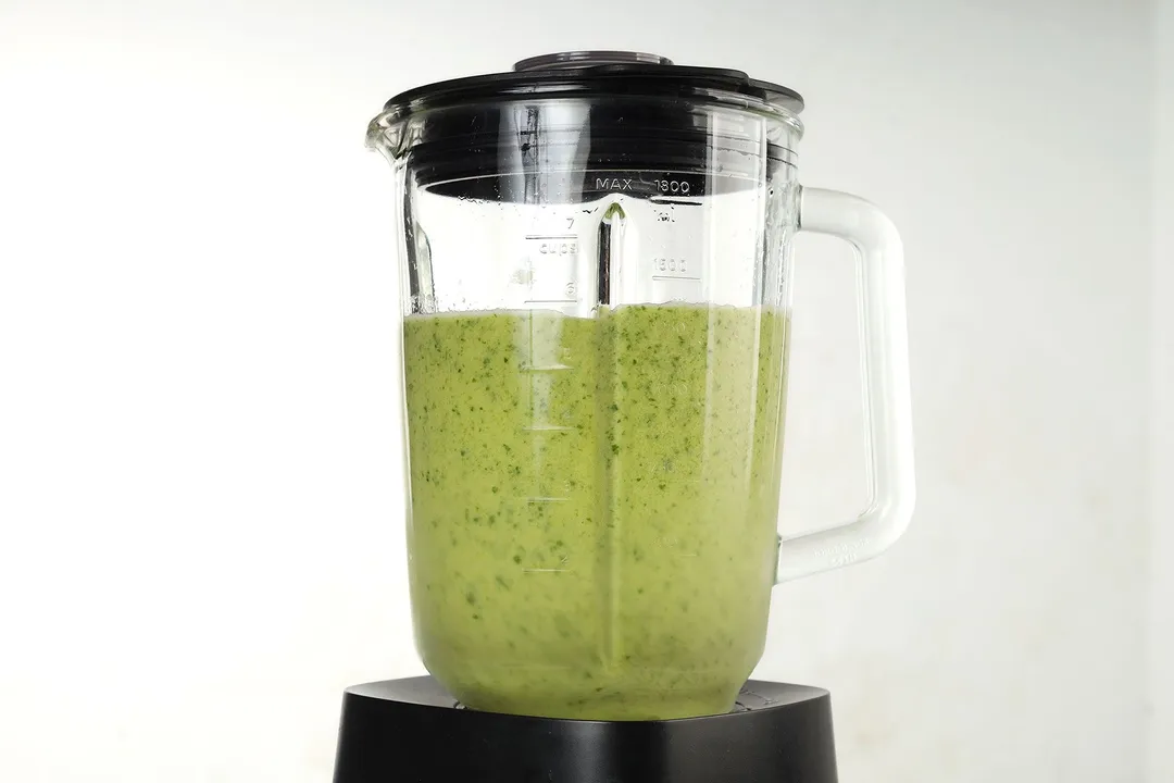 a blender pitcher of green smoothie