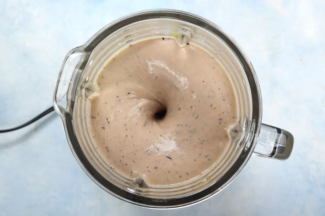 top view of a blender pitcher with blueberry avocado smoothie in it.