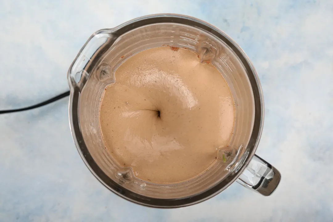 top view of a blender pitcher blending chocolate and avocado smoothie.