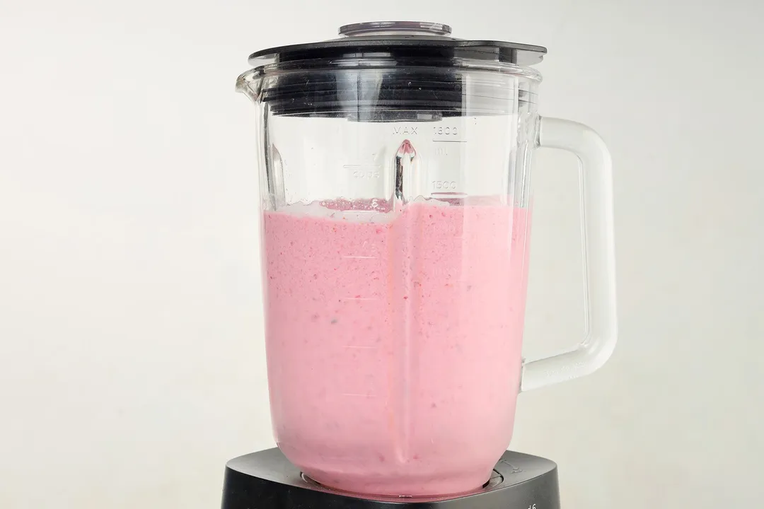 front shot of a blender pitcher with pink smoothie in it