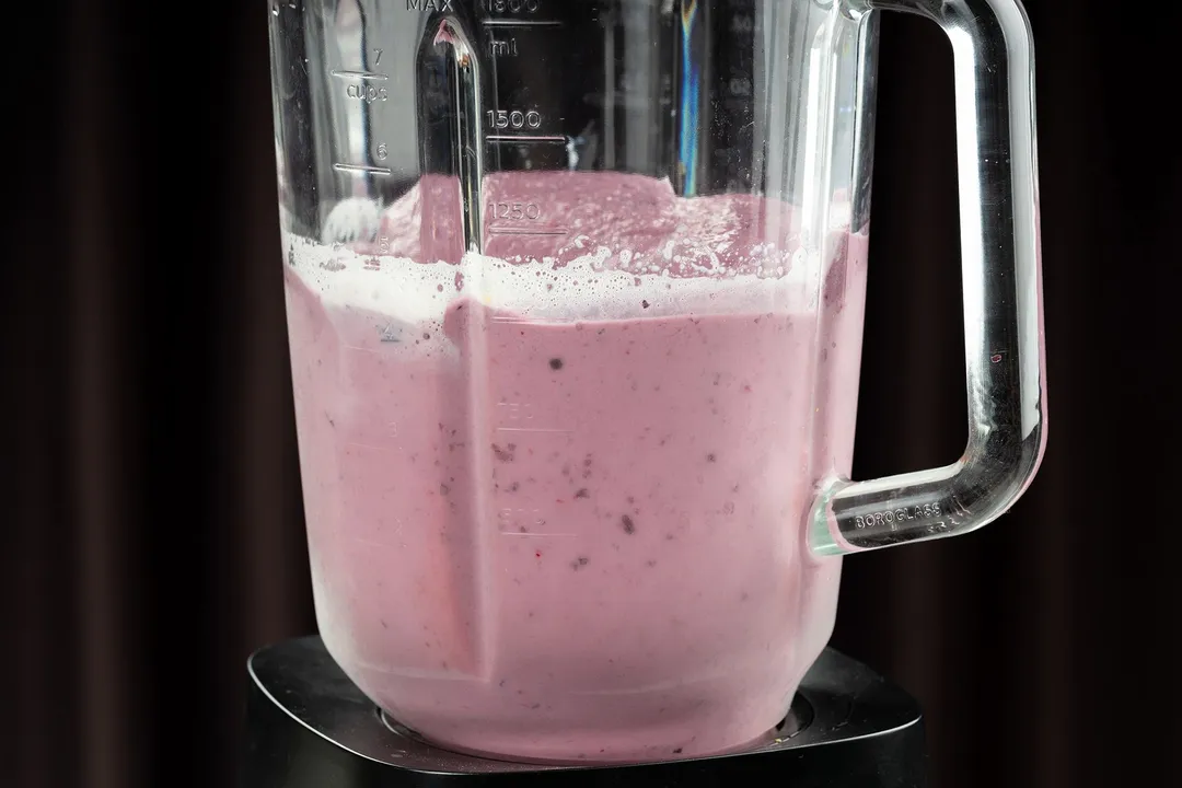 a blender blending pink smoothie