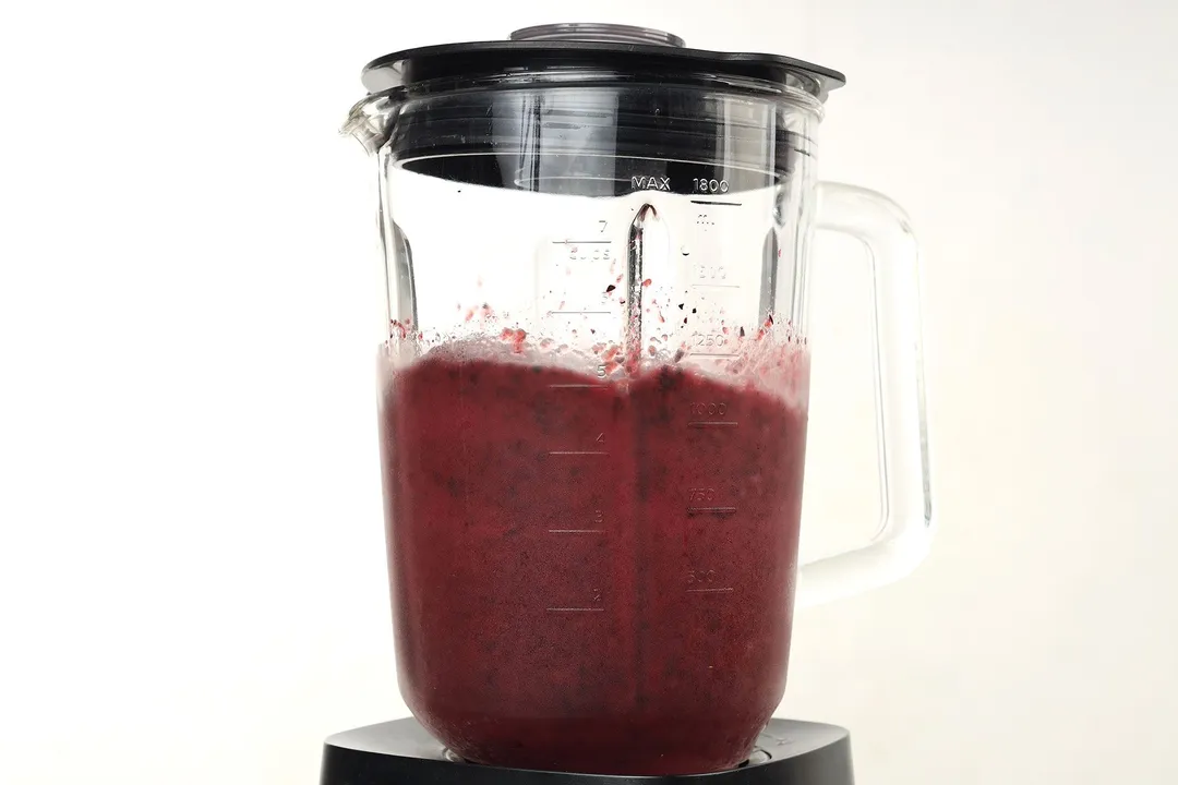 A blender blending a dark purple liquid