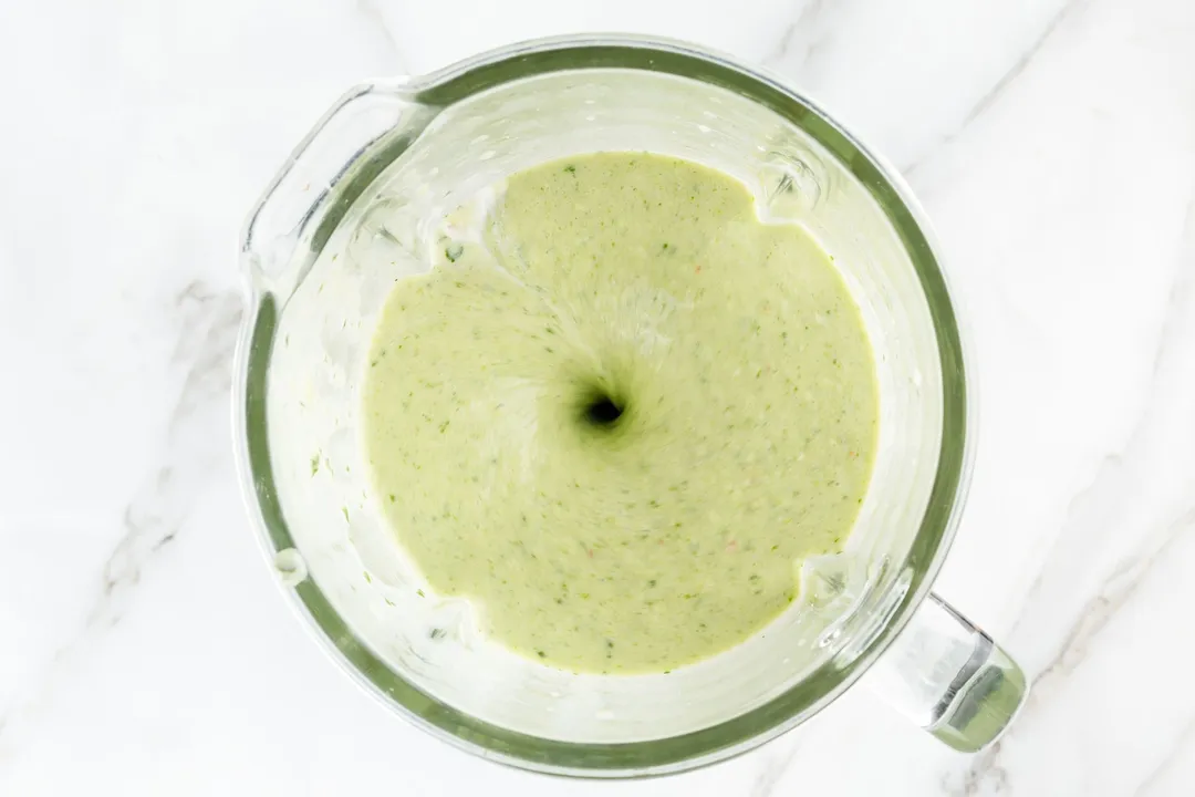 top view of mango and spinach smoothie in a blender