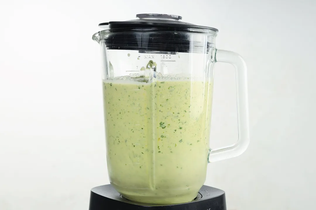 front shot of a blender with mango spinach smoothie in it