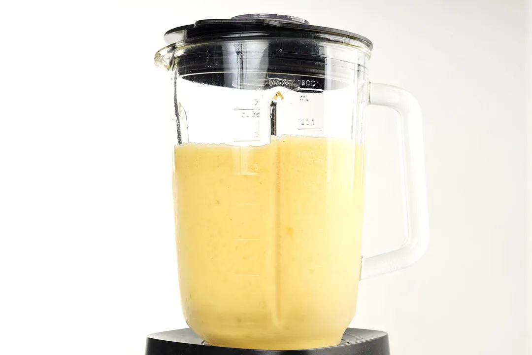 front shot of a blender pitcher with orange smoothie in it