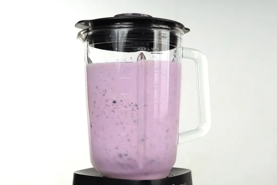 a front shot of a blender pitcher of peanut butter blueberry smoothie
