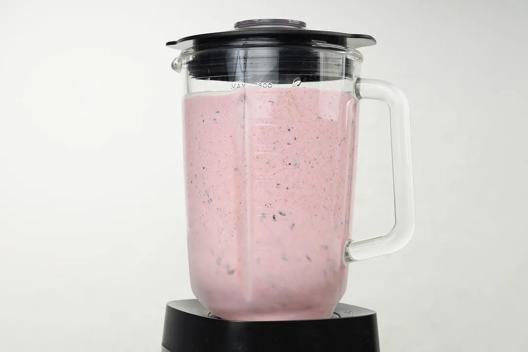 a blender pitcher full of pink smoothie.