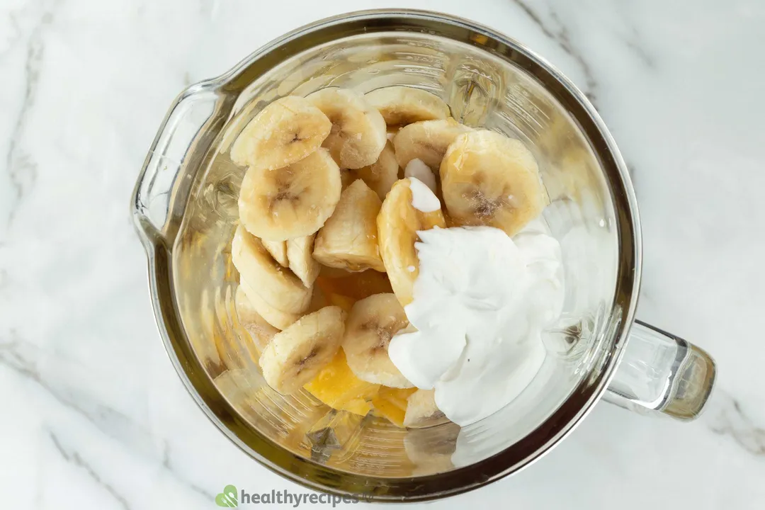 Pineapple, banana and milk in a blender pitcher