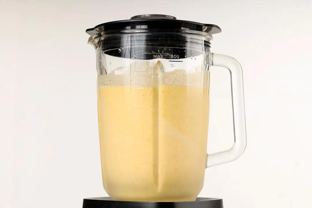 front shot of a blender pitcher with pumpkin pie smoothie in it.