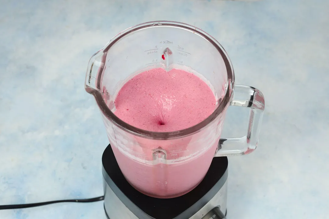 top view of a blender pitcher with pink smoothie in it.