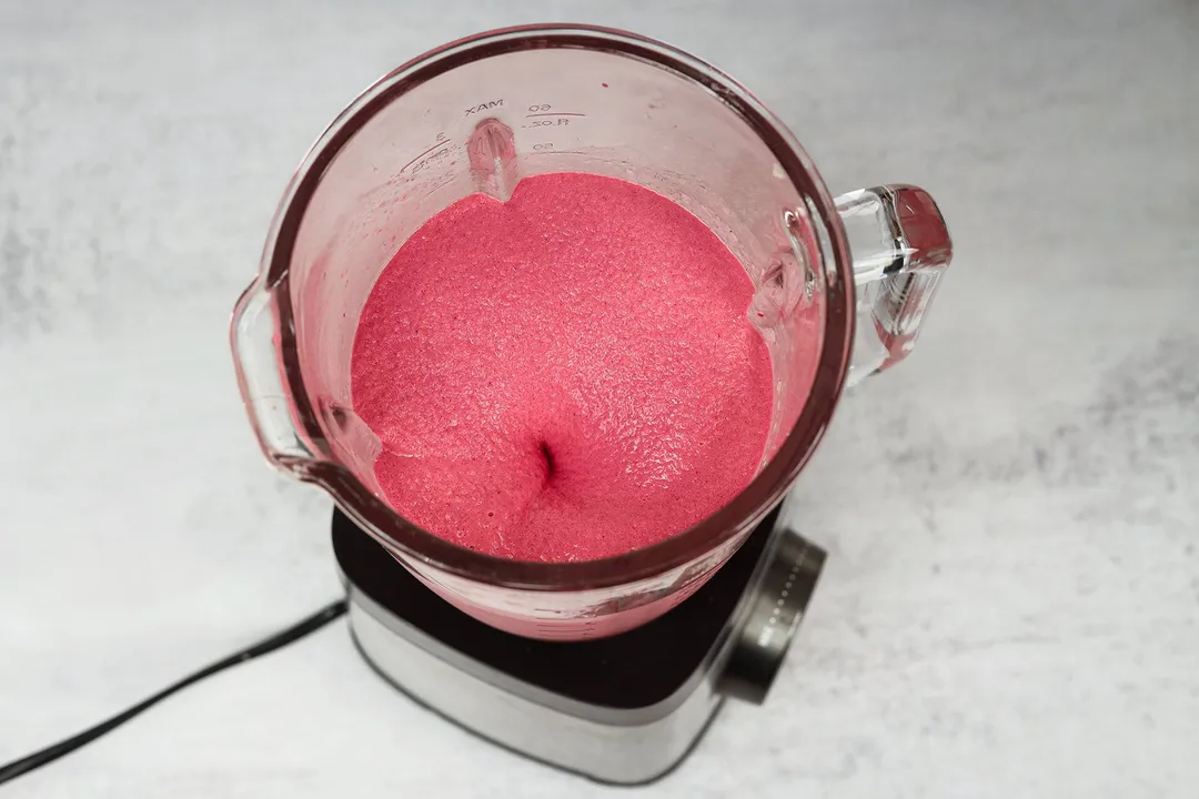 blending raspberry smoothie in a blender