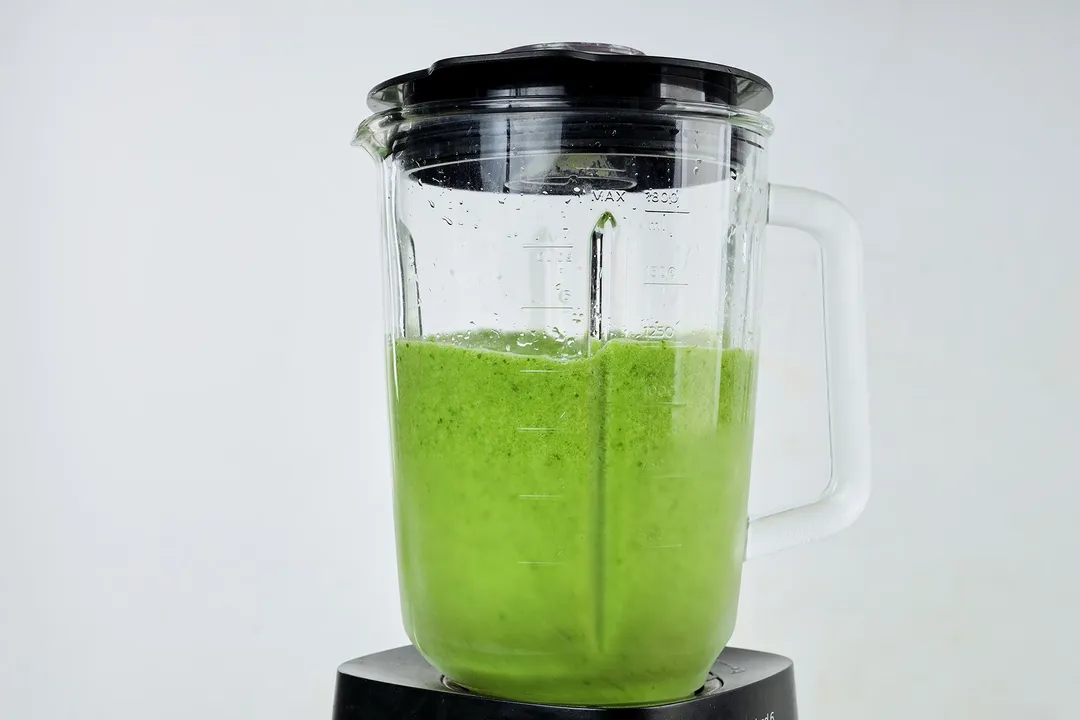 a blender pitcher of sour apple smoothie