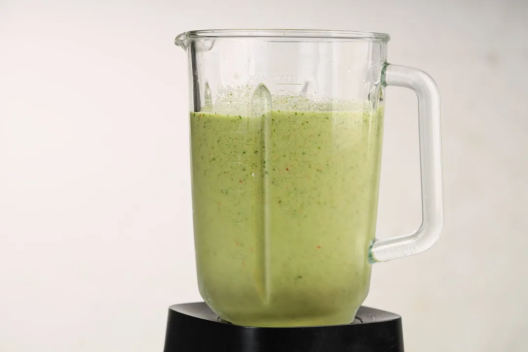 front shot of blender pitcher with spinach fruit smoothie in it