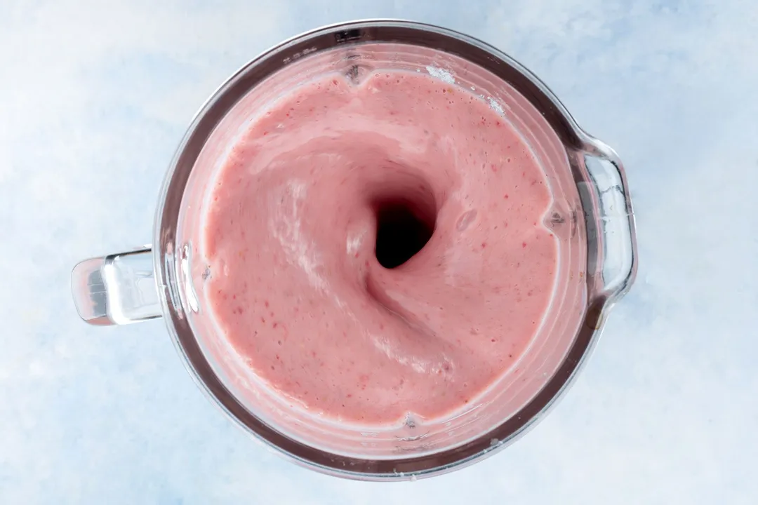 a blender pitcher full of pink smoothie