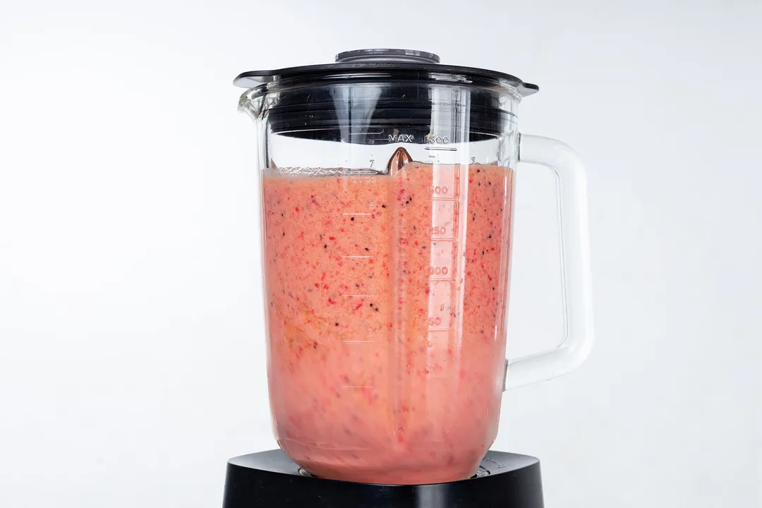 a blender pitcher full of strawberry smoothie