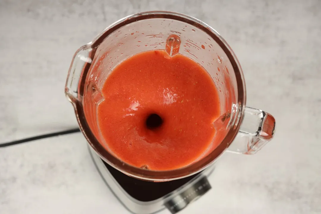 a blender blending strawberry papaya smoothie