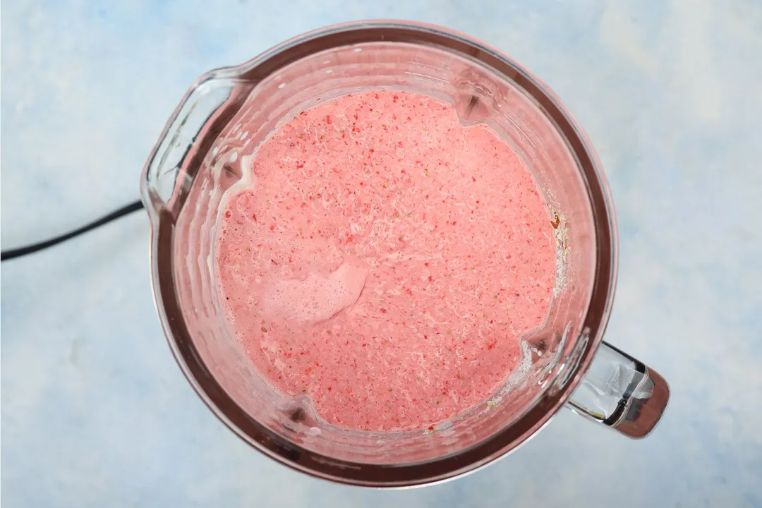 top view of a blender pitcher of strawberry smoothie with yogurt