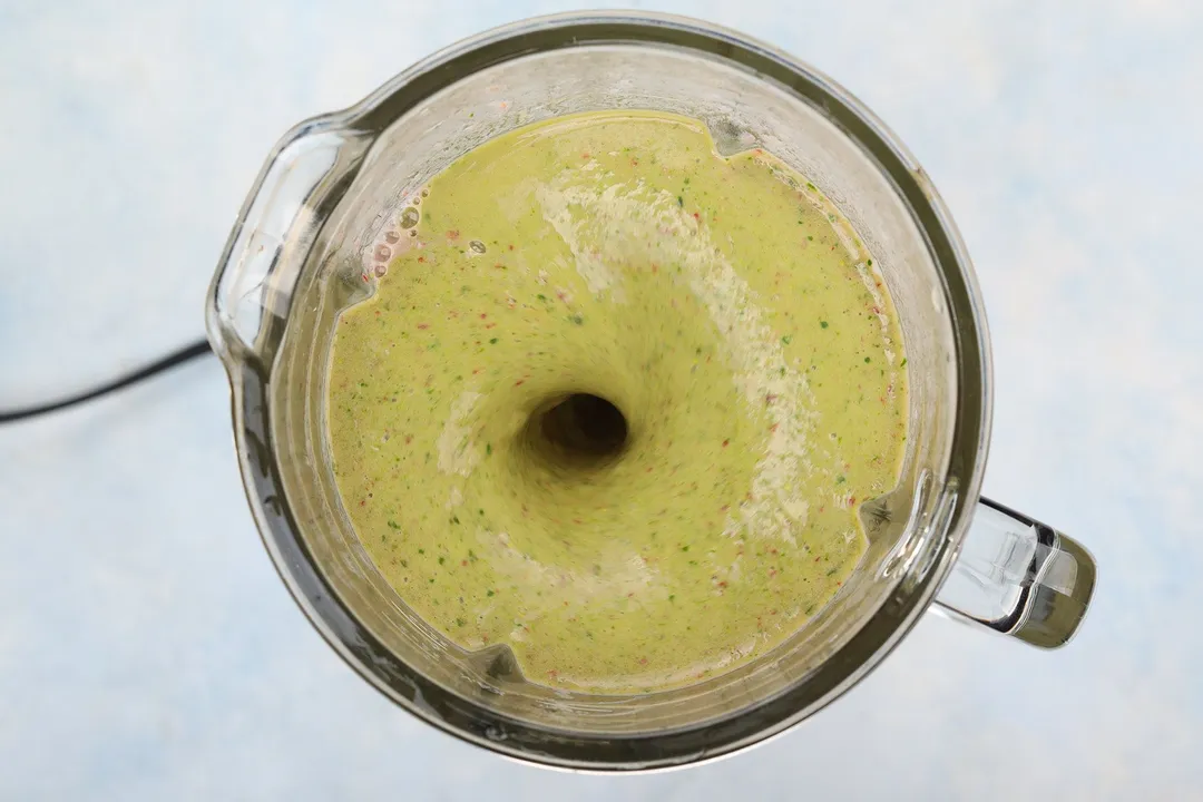 top view of a strawberry spinach smoothie blending in a blender