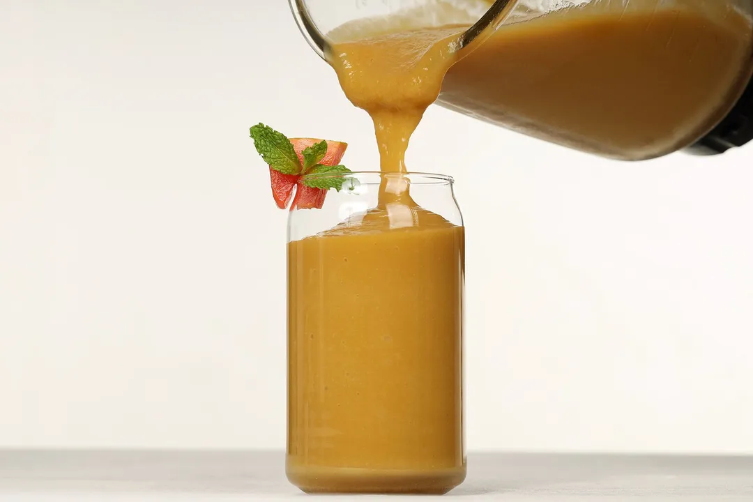 a pitcher pouring smoothie in to a glass