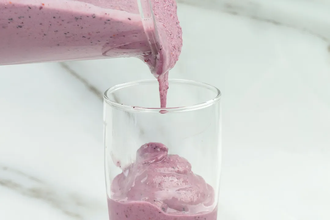 frozen smoothie pouring from pitcher into glass