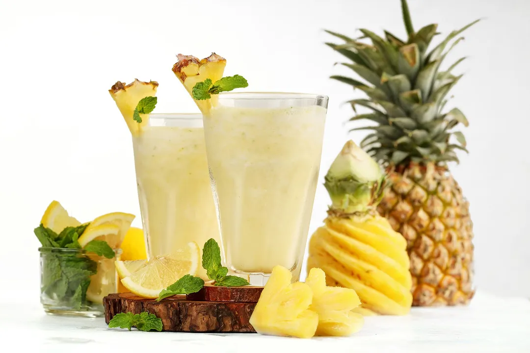 two glasses of smoothie garnish with pineapple