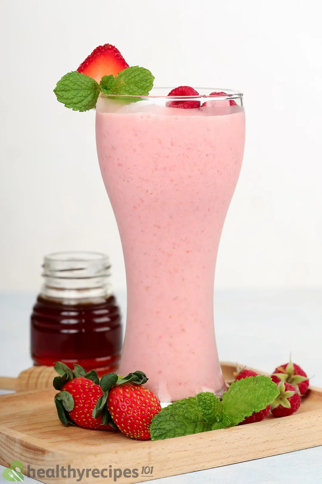 a glass of strawberry raspberry smoothie on a tray