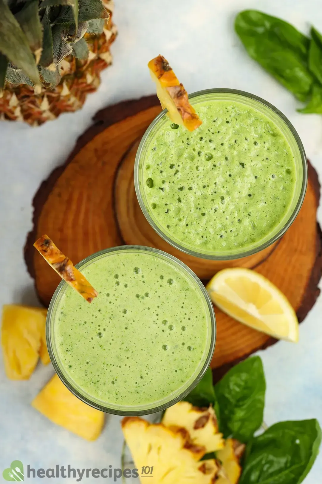 Two green smoothie glasses taken from above, put next to garnishes