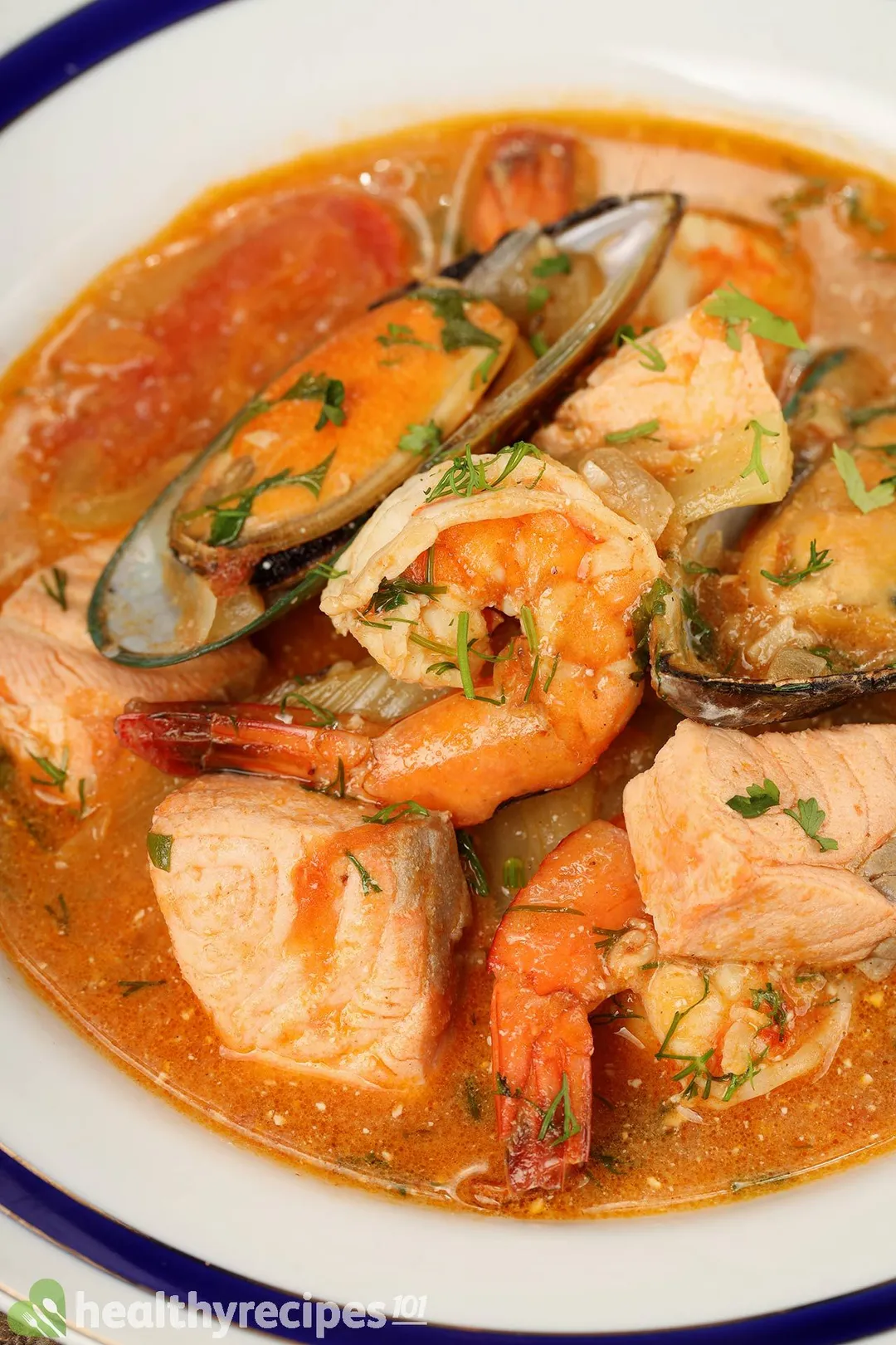 a plate of seafood soup with cooked shrimp, mussel and salmon