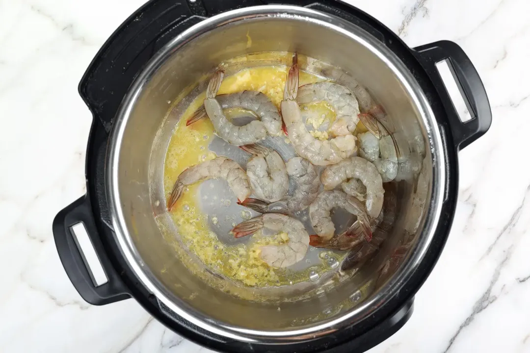 Saute the garlic and sear the shrimp