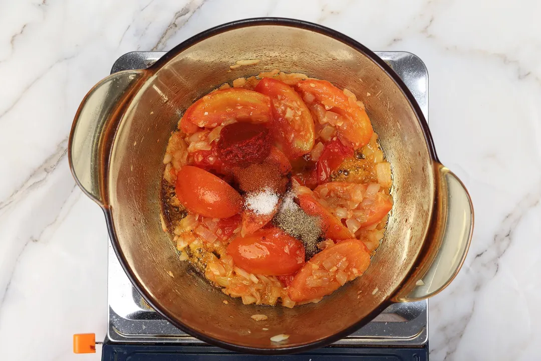 cooking tomato and seasoning in a pot