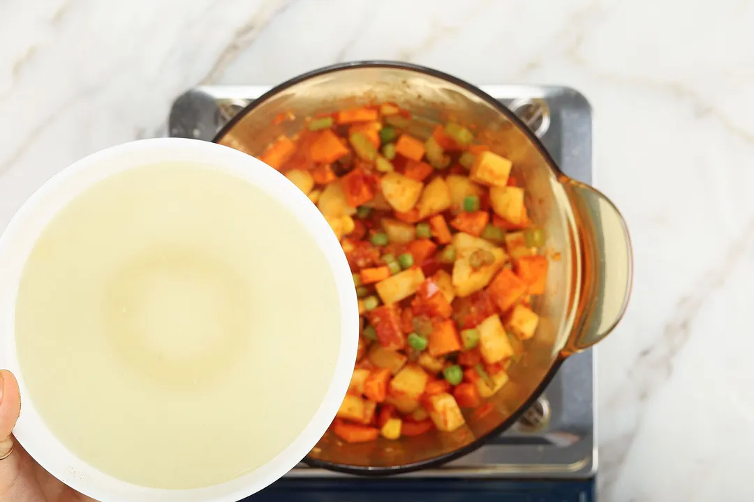 a bowl of chicken broth on top of a pot of vegetable
