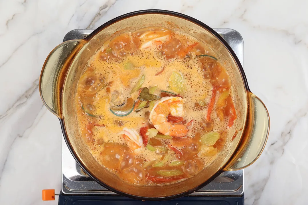 cooking shrimp mussel soup in a pot