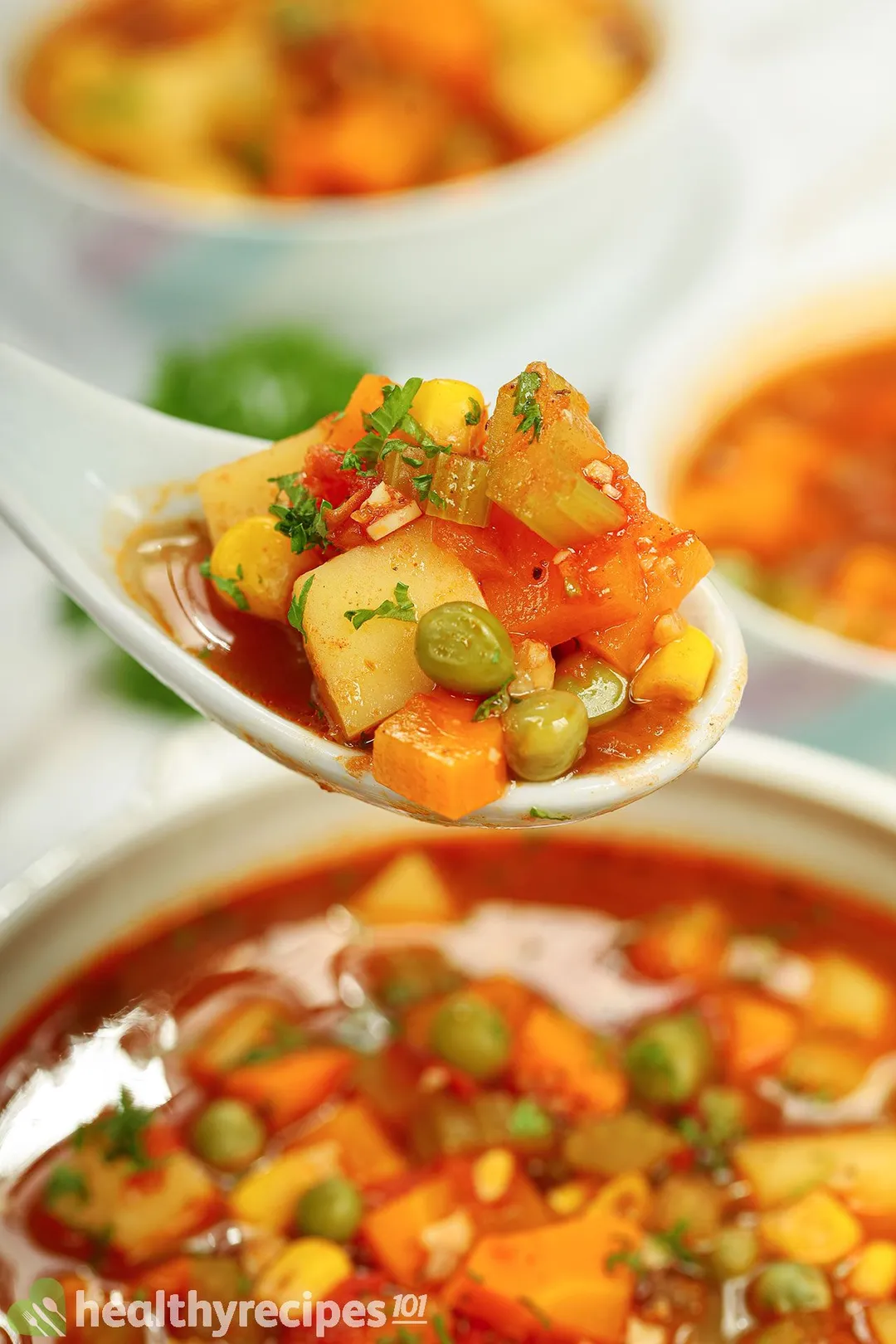 a spoon of vegetable soup on top of a bowl of soup