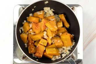 step 4: In a deep skillet or pot, heat olive oil over medium heat. Add the onion and pumpkin.