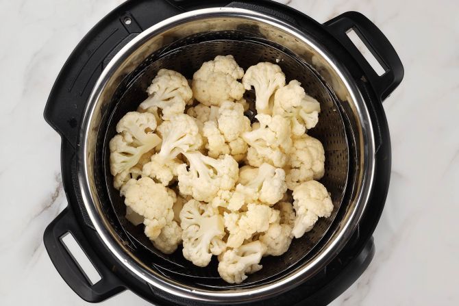 Step 1: Arrange cauliflower florets on a steamer basket and add water. Close the lid, seal the valve, and cook on the “Steam” setting for 15 minutes.