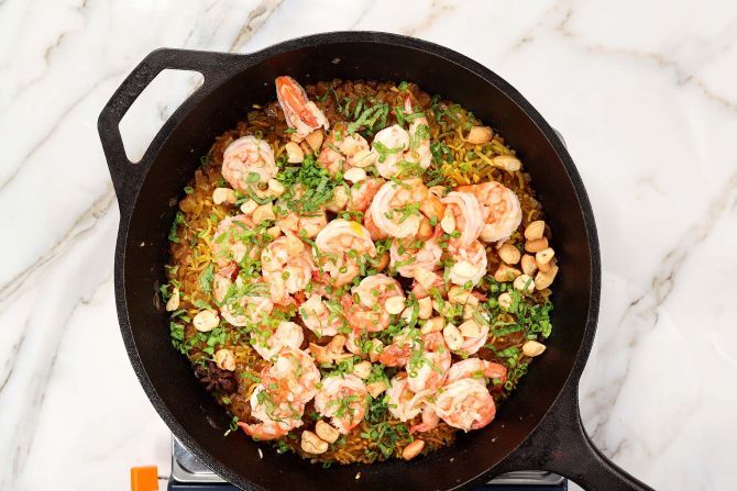 Return the cooked shrimp to the skillet with mint leaves, chopped cashew, and chopped scallions.