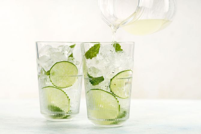 step 2: Lightly muddle the mint and lime slices. Fill the glasses with ice cubes. Pour the rum and lime juice mixture