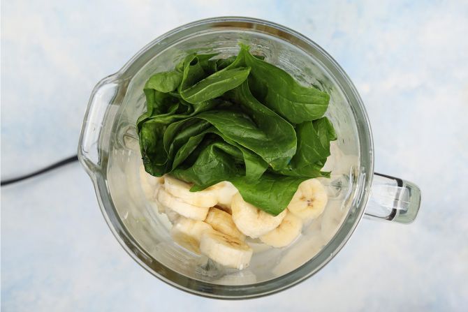 Step 2: Add in the banana, milk, yogurt, honey, and spinach. Blend the mixture.