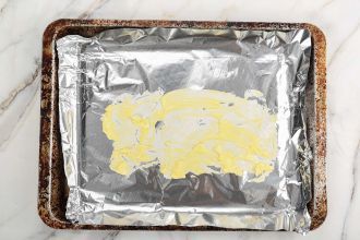 step 2: Line the baking tray with foil and grease it with butter.