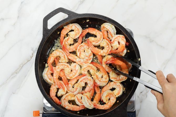 step 2: Add the peeled shrimp and stir to cook.